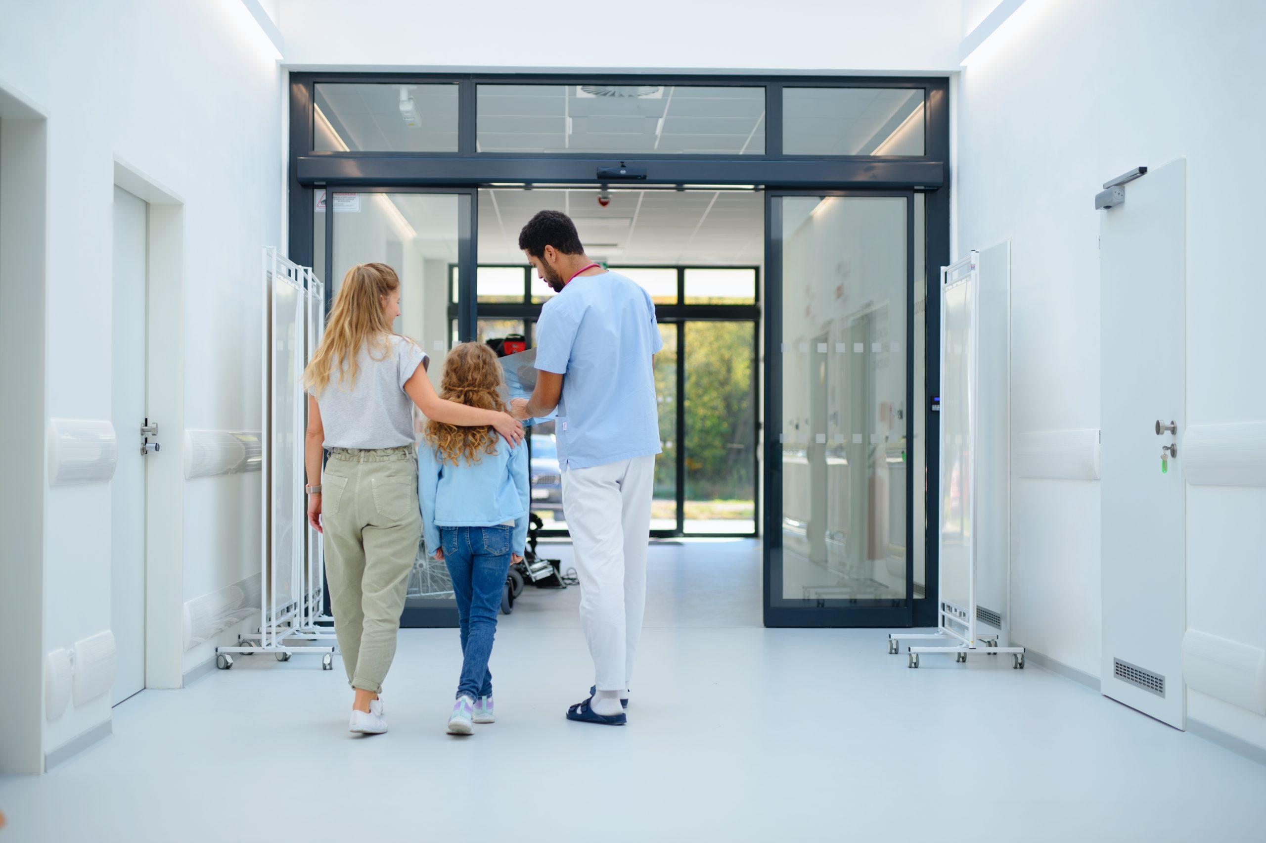 Rearview of a young couple and a little girl in a clinical setting