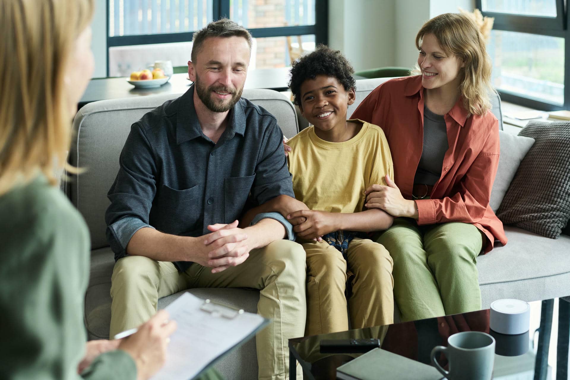 Smiling Husband and wife with their kid in a therapy office.