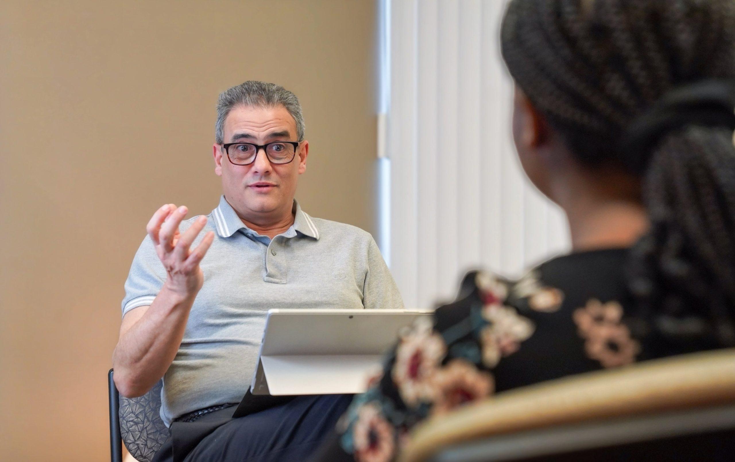 Samir speaking with the female client with eyebrows raised