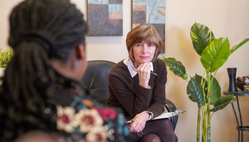 Ruth leaning into a conversation with a client with a compassionate look on her face.