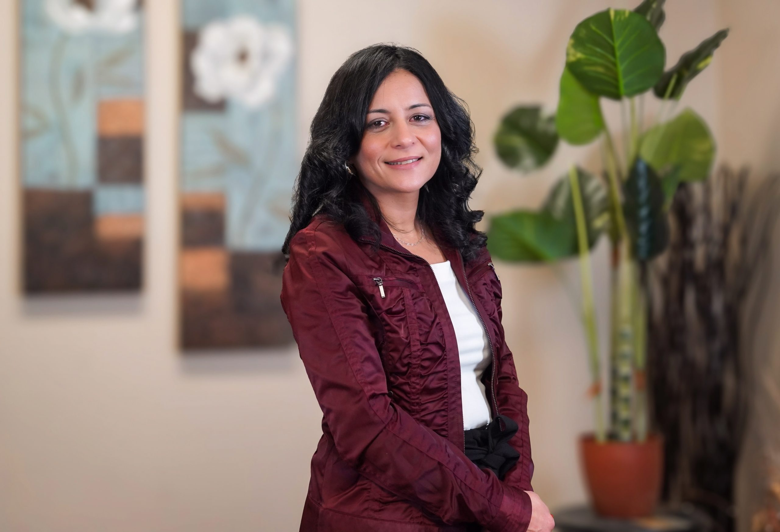 Nesrine smiling at the camera while standing in the office