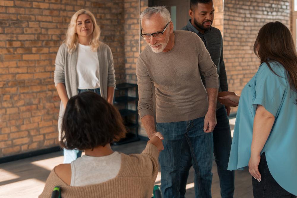 Man greeting a woman in a group therapy session