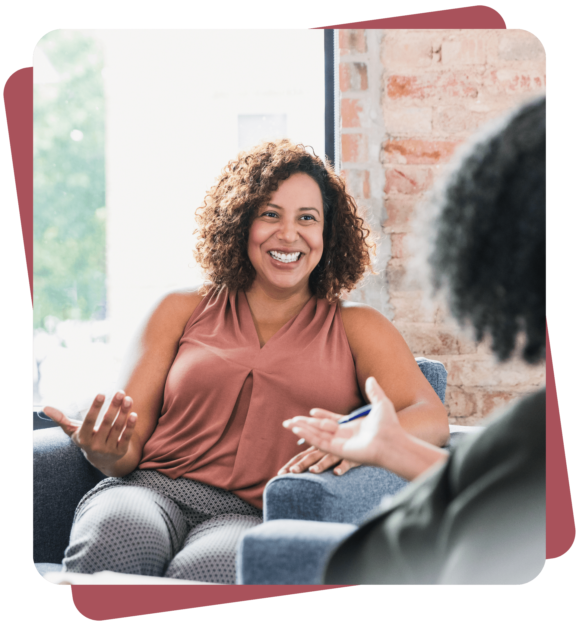 Smiling woman having a supportive conversation with a counsellor in a comfortable office setting.