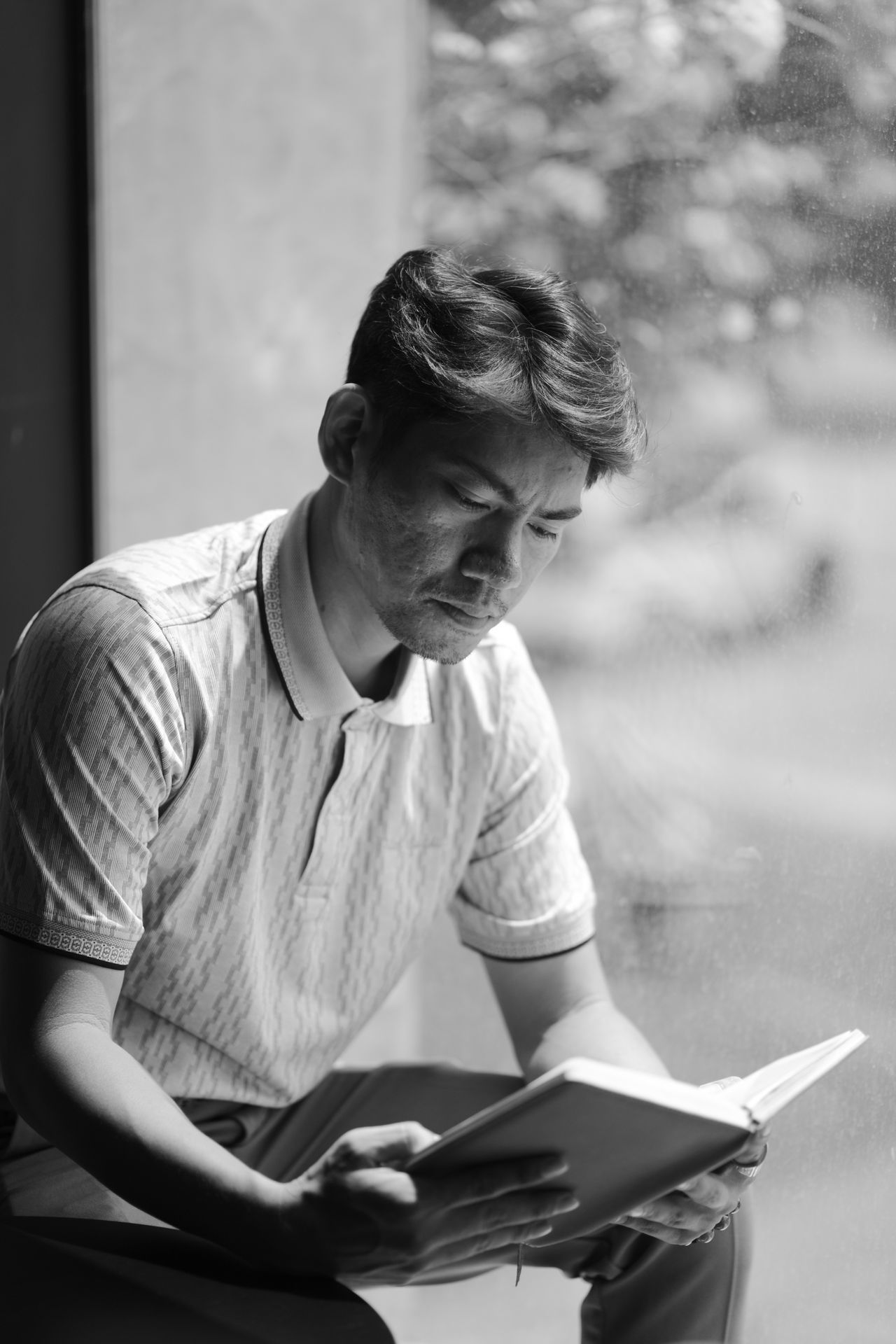 Black and white picture of a man reading a book